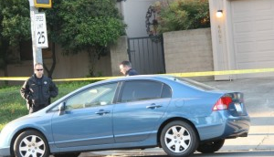 an image of a blue sedan parked outside of a residence with police and police tape around it