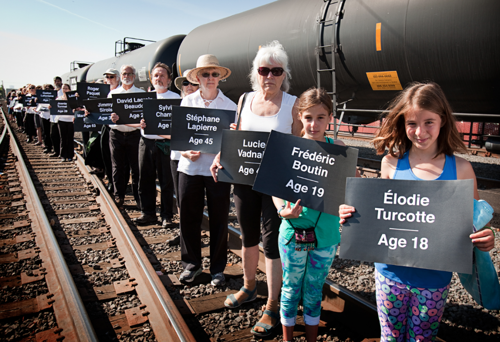 Protesters in Portland carry the names of those who died two years ago when an oil train derailed in Lac-Mégantic, Quebec