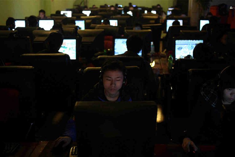 A bunch of people on computers in a dark room