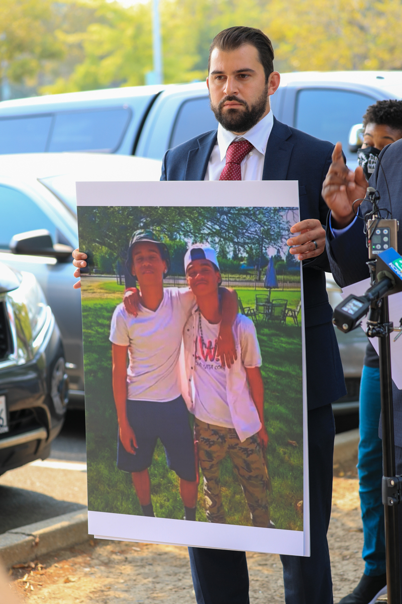image of man holding image of two teenage boys