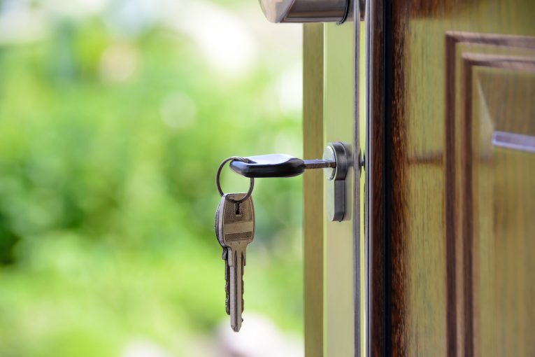 Photo with a green background of keys in a door lock