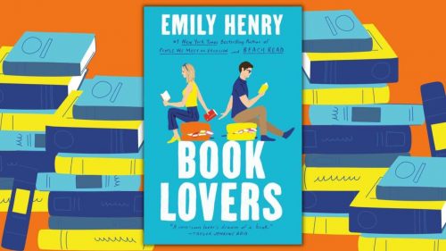 The cover of the book "Book Lovers" by Emily Henry featuers two drawn people both reading books and sitting facing away from each other. They are passing a book between them. The background of the image is stacks of books.